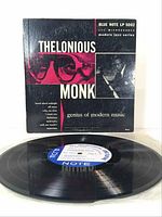 Front cover propped behind vinyl record laid flat