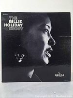 Front cover of The Billie Holiday Story album with black and white profile photo of Billie Holiday and Decca Records logo.