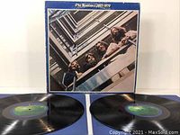 Top-down photo showing two black vinyl records and outer album cover with The Beatles photo.