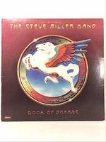 Front view of vinyl record sleeve showing The Steve Miller Band "Book of Dreams" album cover art with winged horse and circular emblem, set on purple background.