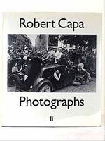 Front cover of Robert Capa "Photographs" book featuring a black and white photograph of a crowd scene with people on a car.