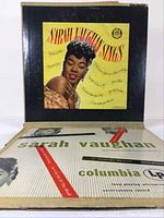 Photo of Sarah Vaughan 'Sings' album cover with yellow background and image of Sarah Vaughan on front.