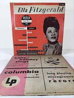 Ella Fitzgerald Souvenir Album vinyl record cover front showing the artist's photo and Decca label information alongside Billie Holiday Sings record sleeve with Columbia label visible.