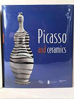 Front view of the Picasso and Ceramics hardcover book with blue dust jacket and ceramic vase artwork on the cover.