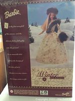 Box front showing Barbie Winter Classic doll in cream gown with brown fur accessories against a snow scene background