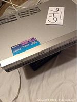 Front angle view of silver Sony SLV-D261P DVD VCR combo player on white cloth background with partial top and side showing ventilation.