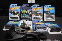 Nine Batmobile vehicles, eight sealed in Hot Wheels blister packs and one loose with Batman figure in the cockpit, shown front and center