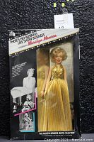 Frontal image of Marilyn Monroe Movie Collection doll in original packaging, showing doll dressed in gold lamé gown and details on box sides.