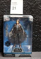 Front view of Star Wars Elite Series Sergeant Jyn Erso die-cast action figure in original packaging with visible accessories including weapons and stand.