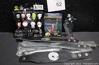 Photo of six leather wristbands, two silver wristbands sealed in plastic, miniature Jack Skellington figurine standing on a base, and three sealed blind bag figures.