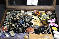 Wide view of a wooden display case filled with various vintage and antique collectibles including pins, figurines, buttons, and small trinkets.