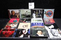 Photo showing an assortment of 13 music CDs with various cover art and genres including classical and pop.