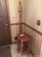 View of the coat rack and accent table positioned against the wall showing both items together.