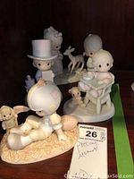 Five different Precious Moments porcelain figurines displayed together showing various designs including animals and children.