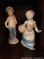 Two porcelain figurines by Rex Valencia of Spain, boy and girl, about 9 inches tall.