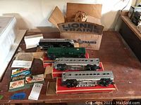 Overview of locomotive, freight car, passenger cars in original Lionel boxes, plus promotional cards.