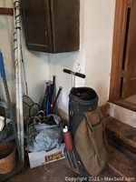 Photo showing golf bag, pogo stick, baseball bats, and other sporting goods.