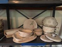 Photo showing Pfaltzgraff serving dishes and bakeware alongside Corning Ware and Linoware pots on metal shelving.