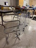 Wide view of towel warmer next to three wire bins on caster wheels