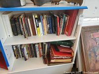 Books and photo albums displayed on shelves showing titles and bindings