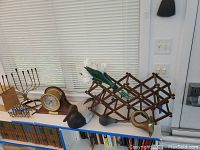 Overview of mantel clock, wooden duck decoy, expandable wine rack, and vintage car-style horn.