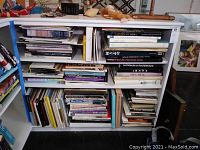Wide view of shelves filled with a large number of art and photography books showing various titles and bindings.