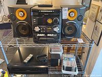 Philips sound system with two speakers on shelf, 3-disc CD player showing model and power info