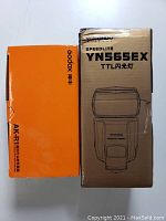 Boxes of Yongnuo YN565EX Speedlite flash and Godox AKR1 round flash head accessory kit
