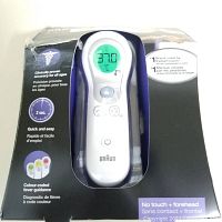 Front view of the Braun no touch thermometer in packaging showing the digital display and buttons.