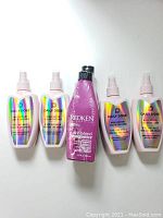 All five bottles including four Daily Dose Miracle Moisture Leave-In Conditioner and one Redken Color Extend Magnetics Shampoo and Conditioner, displayed side by side.