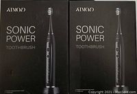 Two boxed Atmoko Sonic Power electric toothbrushes seen from front showing brand and product name.