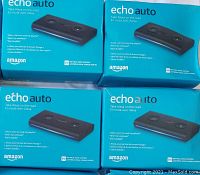 Four boxed Amazon Echo Auto devices showing packaging and product images