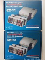 Two boxed Mini Game Anniversary Edition consoles showing packaging with description of 620 built-in classic games.