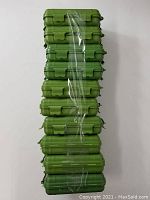 Stack of 10 green waterproof hard cases sealed with plastic wrap