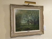 Frontal view of entire oil painting in carved wooden frame, hanging on wall