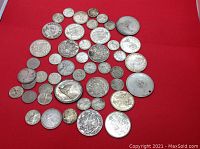 Flat lay of approximately 45 mixed Canadian silver coins on red background showing a range of denominations and dates