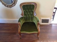 Front view of green velvet Victorian-style armchair