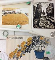 Three paintings laid out together: rice-field landscape, monochrome print of shepherd and flock, chrysanthemum painting.