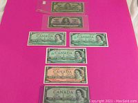 Seven notes arranged on pink background; two in protective sleeves