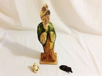 All three pieces on white backdrop: court lady, small netsuke, and wood foo dog.