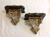 Pair of bronze wall sconces showing intricate bronze work and faux marble painted wooden tops.