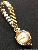 Close-up front of watch case and expansion bracelet on black background