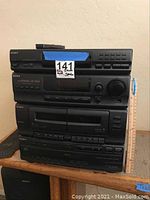 Front view of the stacked Sony stereo system components including tuner, CD player, tape deck, and amplifier with remote control on top.
