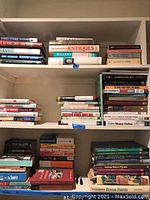 Three shelves filled with assorted books including antiques, plants, business, and fiction genres.