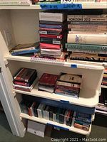 Photo showing stacked audio books on CDs on bottom two shelves and various health books on the top shelf, some visible titles related to cancer and breast cancer support.