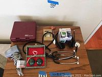 Photo showing Conair Twist n Curl Trio hair styler case, Vidal Sassoon MistyTone hair dryer, blood pressure monitor box, two stethoscopes, Baoding balls in pouch