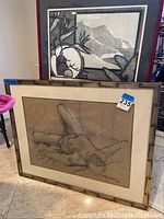 Framed charcoal sketch of a reclining male nude figure on beige paper, large frame sized about 31 1/2 x 25 inches, leaning against the floor