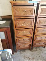 Front view of wooden chest of drawers with rope-wound decorative panels and five drawers with metal ring handles.