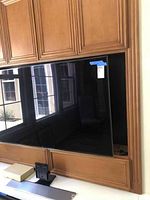 Front view of the 65 inch Samsung LED Smart TV mounted in cabinetry, label visible.