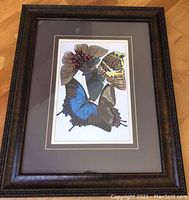 Frontal view of framed butterfly wall art showing colorful butterfly illustrations and ornate brown frame.